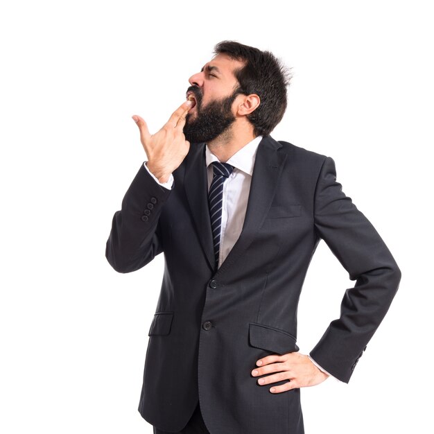 Businessman making gun gesture over white background