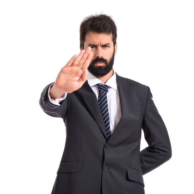 Businessman making stop sign over white background