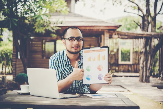 Businessman in a meeting or presentation hand pointing with business chart document on the table.