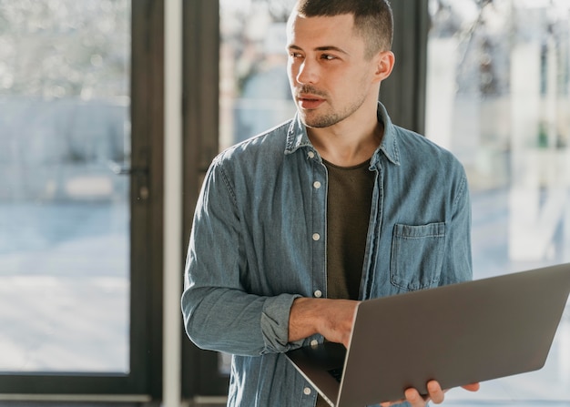 Businessman at office with laptop portrait