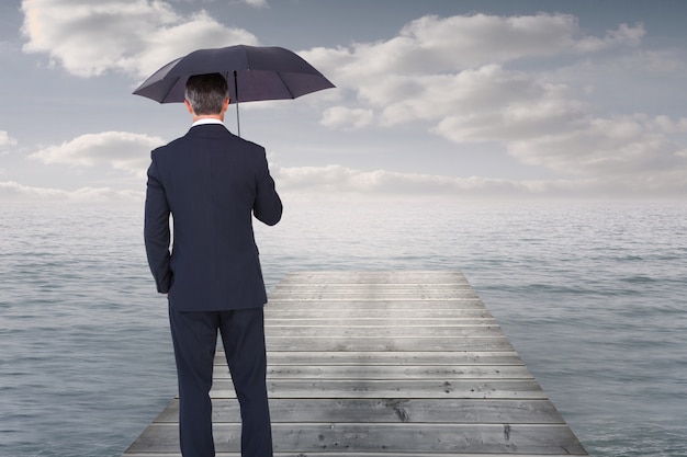 Businessman on a platform surrounded by water