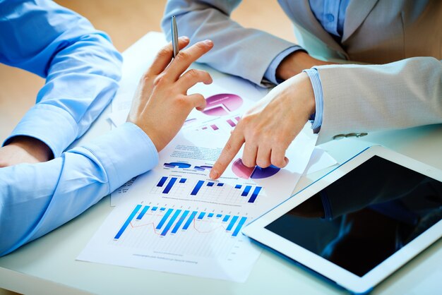 Businessman pointing a bar graph to a teamwork