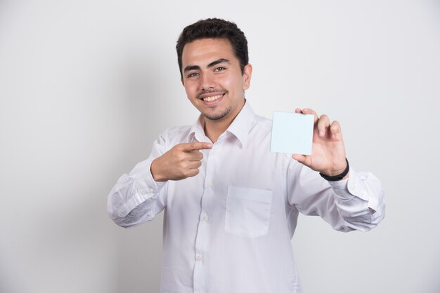 Businessman pointing at memo pads on white background.
