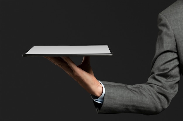 Free photo businessman presenting invisible hologram projecting from tablet advanced technology