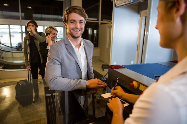 Businessman in queue receiving passport and boarding pass