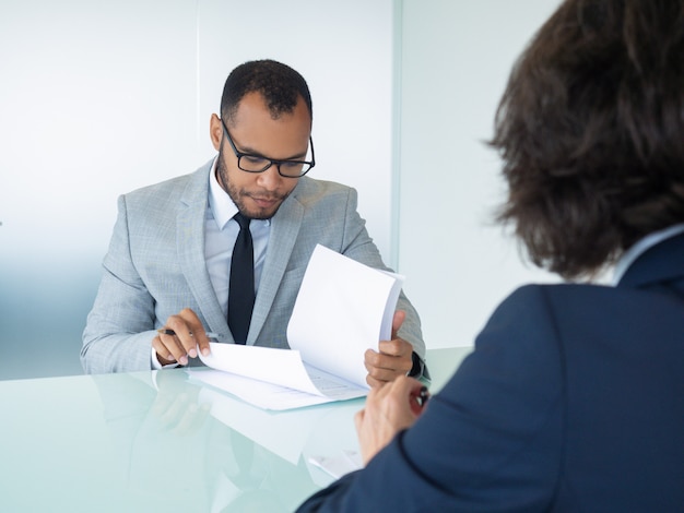 Businessman reading contract during meeting