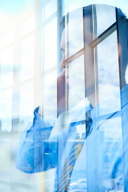 Businessman reflection in front of window