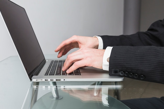 Businessman's hand typing on laptop keypad