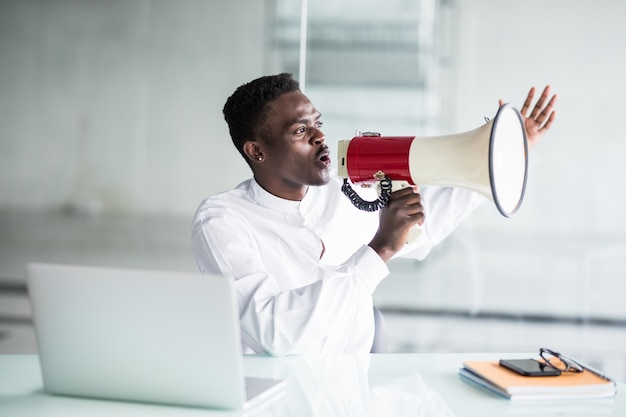 Businessman scream yelling through a megaphone in the office