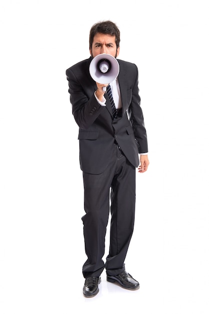 Businessman shouting by megaphone over white background