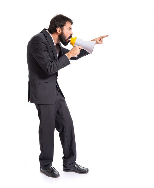 Businessman shouting by megaphone over white background