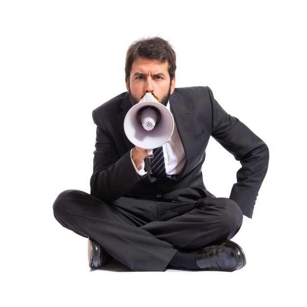 Businessman shouting by megaphone over white background