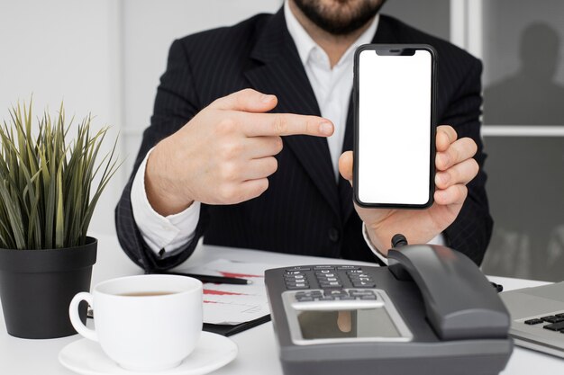 Businessman showing mobile phone