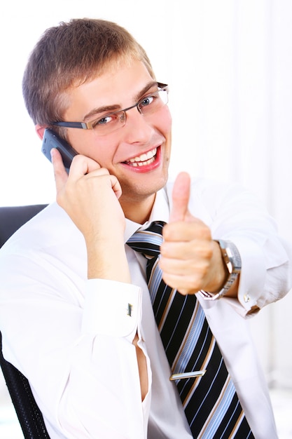 Businessman shows OK sign while calling by phone