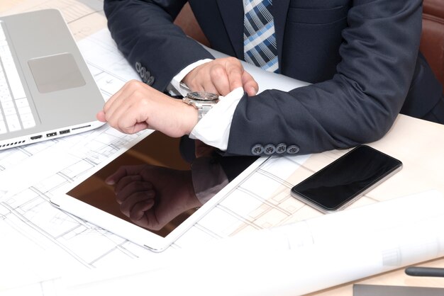 businessman sitting in the office and looking on the watch