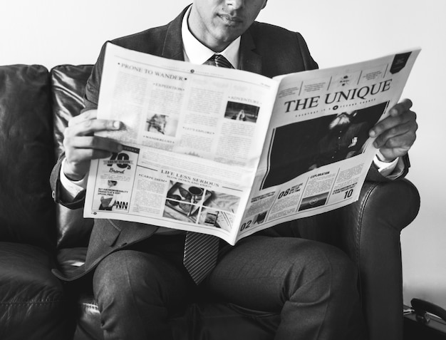 Businessman sitting and reading newspaper