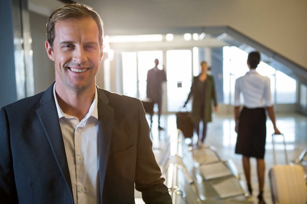 Free photo businessman smiling at airport terminal