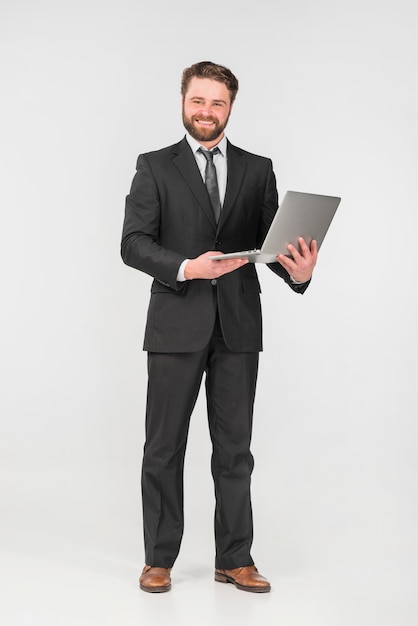 Businessman smiling and using laptop 