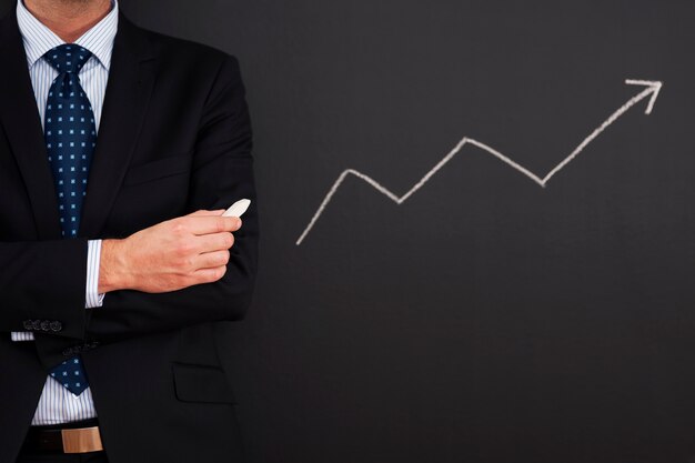 Free Photo businessman standing close to arrow sign