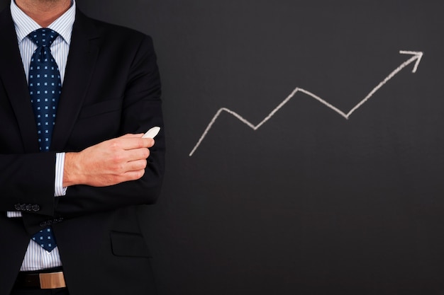 Businessman standing close to arrow sign