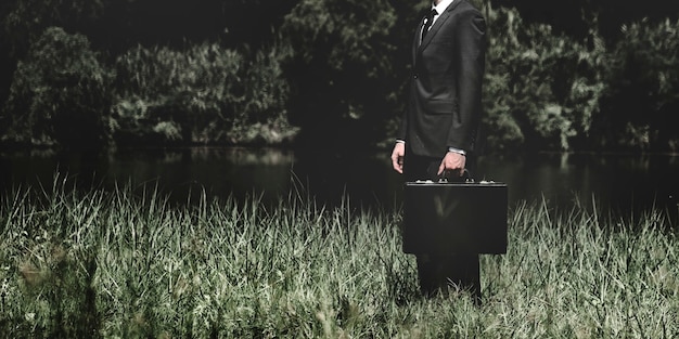 Free photo businessman standing on a grass outdoors