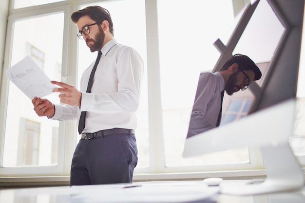 Free photo businessman standing and holding a document