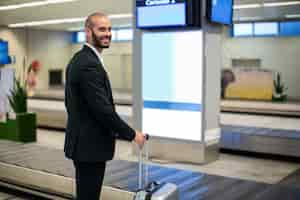 Free photo businessman standing with luggage bag in airport