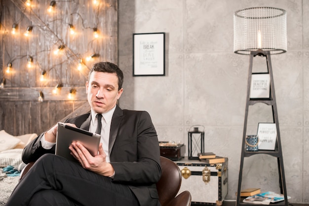 Businessman in suit browsing tablet 