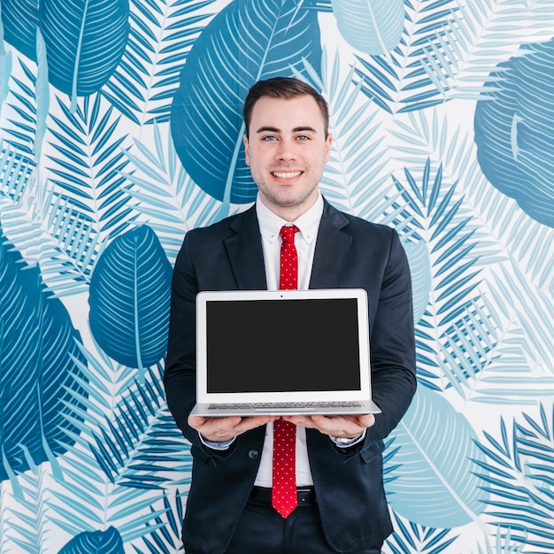 Free photo businessman in suit showing laptop