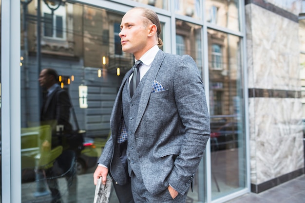 Businessman in suit standing in front of glass window