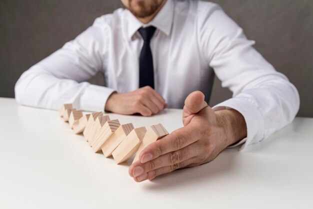 Businessman in suit and tie holding domino pieces