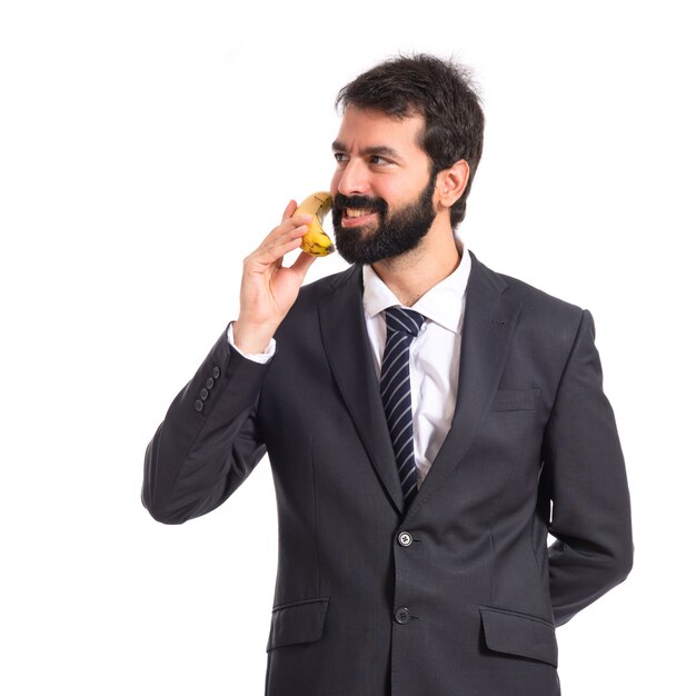 Businessman talking by banana over white background