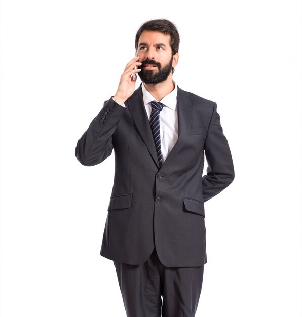 Businessman talking to mobile over white background