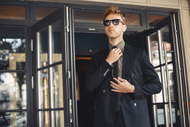 Businessman talking on the phone and holding a folder in his hands. Man in sunglasses.