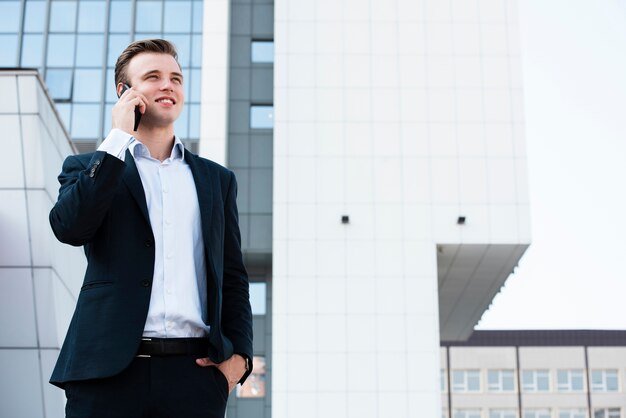 Businessman talking on the phone near building