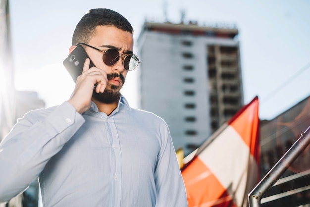 Free photo businessman talking smartphone in city