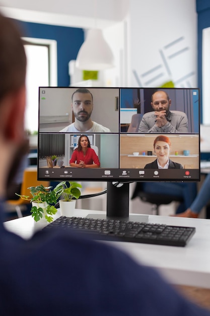 사업가는 스타트업 회사 사무실에서 온라인 화상 통화 회의 중에 원격 팀 계획 관리 전략과 함께 이야기합니다. 컴퓨터 화면에서 원격 회의 통화