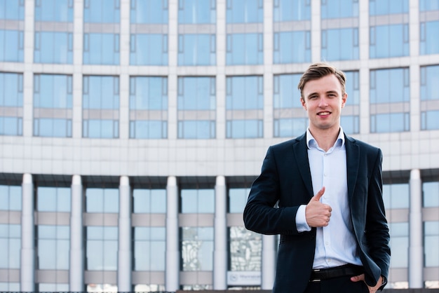 Free photo businessman thumbs up looking at camera