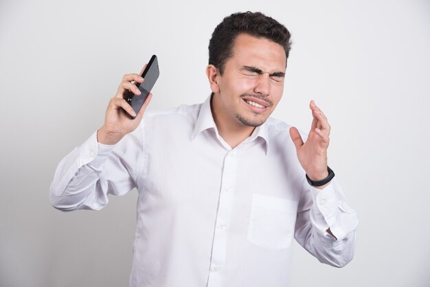 Businessman trying to get away from telephone on white background.