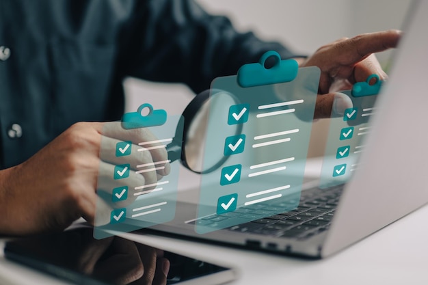 Businessman use magnifying glass with a checklist on clipboard paper successfully complete business assignments Premium Photo