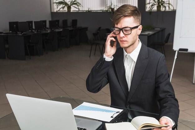 Free photo businessman using cellphone in office