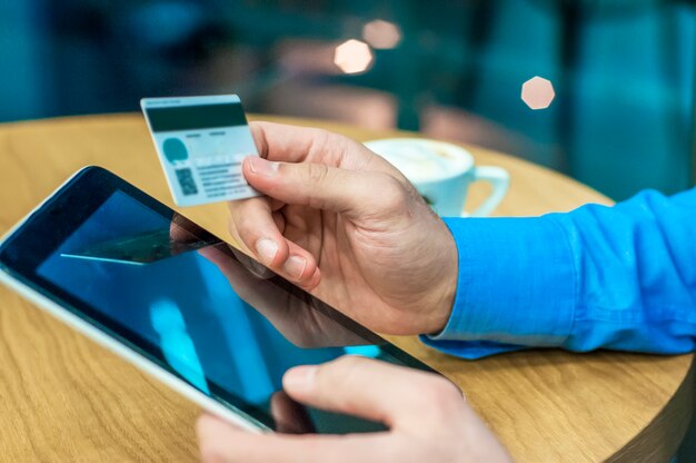 Бизнесмен с помощью кредитной карты и цифровой планшет для покупки он-лайн. Человек, покупающий в Интернете