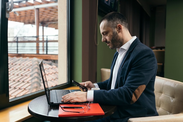 Businessman using laptop and smartphone