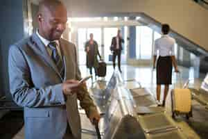 Free photo businessman using mobile phone in waiting area