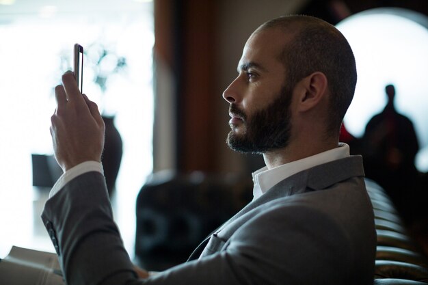 Businessman using mobile phone in waiting area