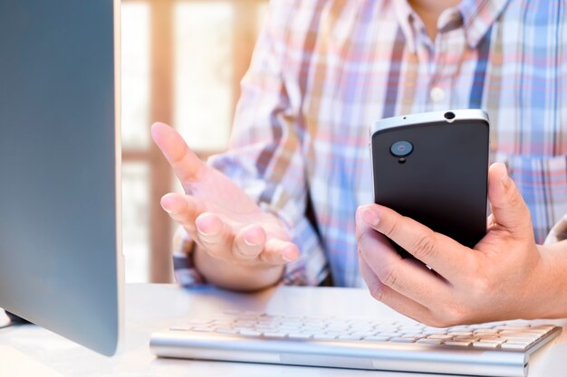 Businessman using smartphone and computer to analize information