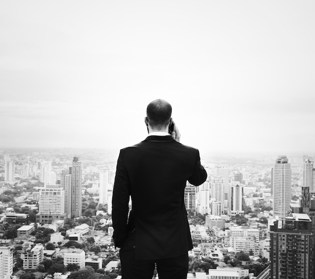 Businessman using smartphone on the top of a building