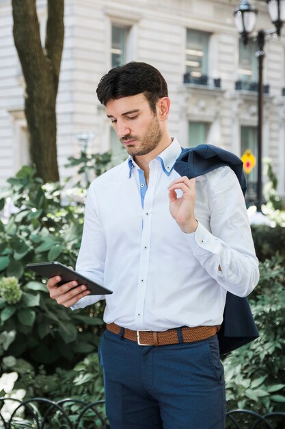 ストリートでタブレットを使用しているビジネスマン