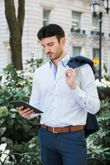 Businessman using tablet on street