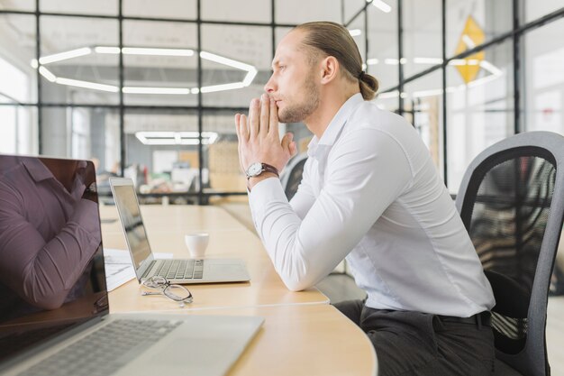 Businessman waiting in front of laptop